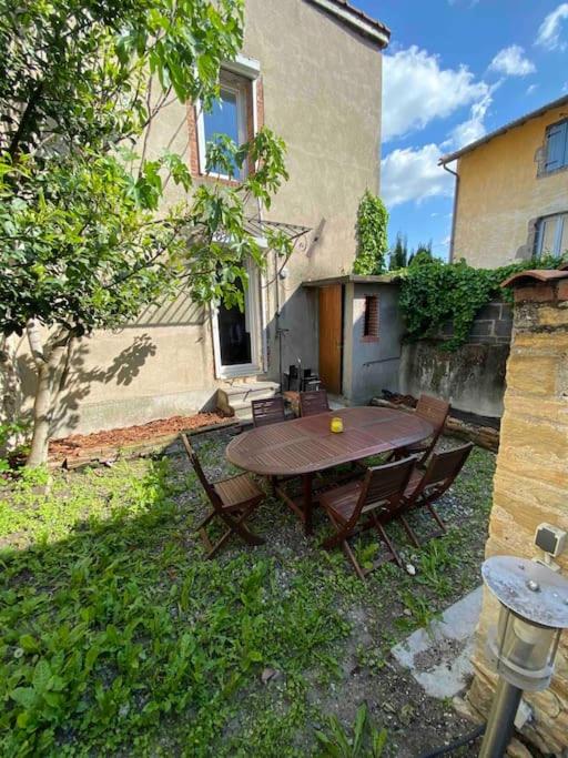 - une table et des chaises en bois dans l'arrière-cour d'une maison dans l'établissement NEW Maison avec Jardin 5 pers, à Le Cendre