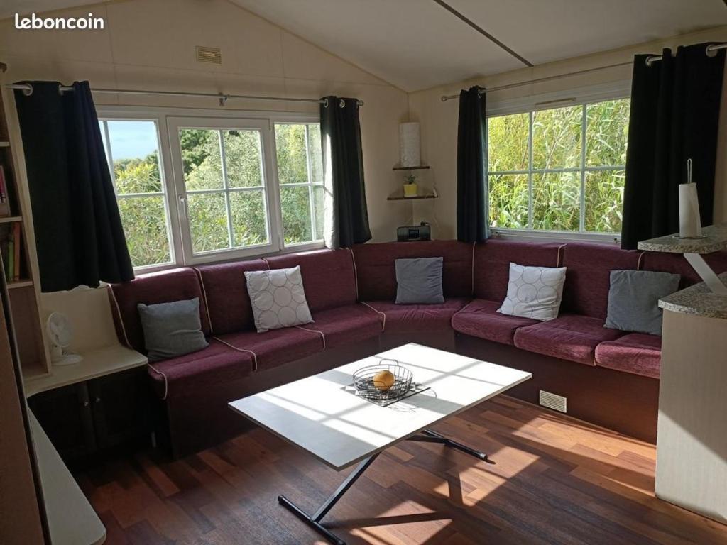 un salon avec un canapé et une table dans l'établissement Mobilhome dans camping Site de Gorge Vent à Fréjus, à Fréjus