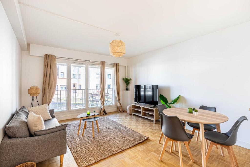 een woonkamer met een bank en een tafel bij GuestReady - Charming living near Paris in Aubervilliers