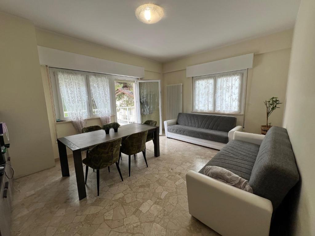 ein Wohnzimmer mit einem Tisch und einem Sofa in der Unterkunft Alba Apartment - Only Family in Riccione