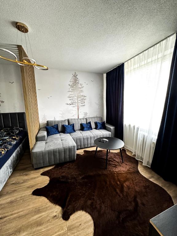 a living room with a couch and a table at Apartmán Lesa Brezno in Brezno