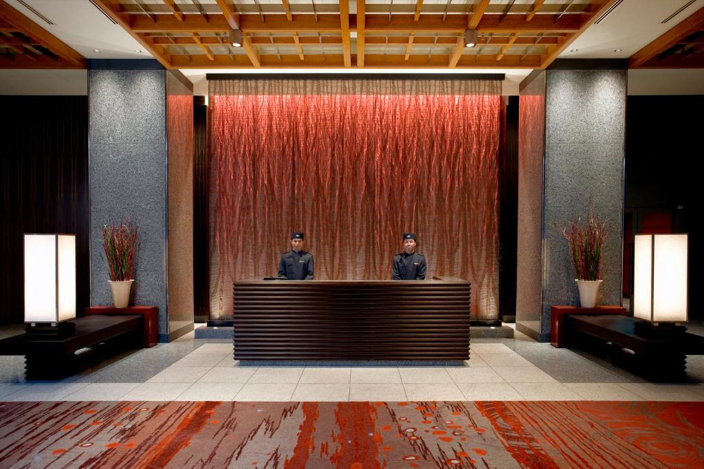two men standing behind a reception desk in a lobby at Mandarin Oriental, Tokyo in Tokyo