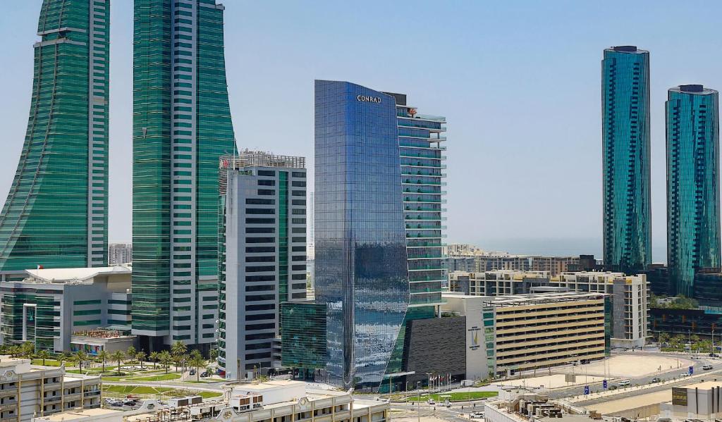 een groep hoge gebouwen in een stad bij Conrad Bahrain Financial Harbour in Manamah