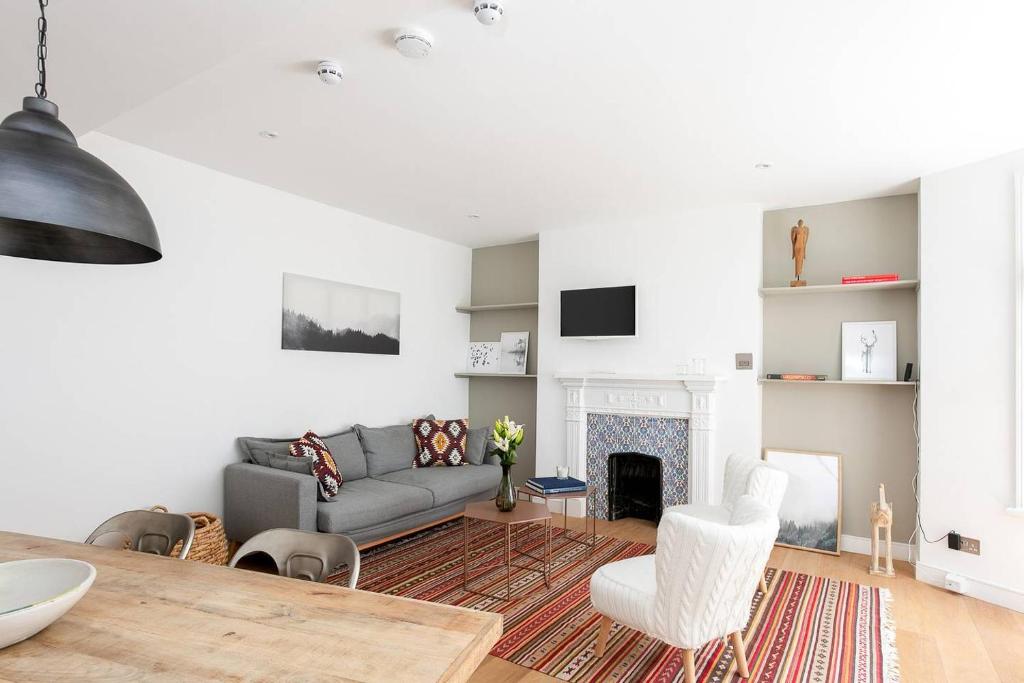 a living room with a couch and a fireplace at Stylish 2BR Home in West Kensington , 4 guests in London