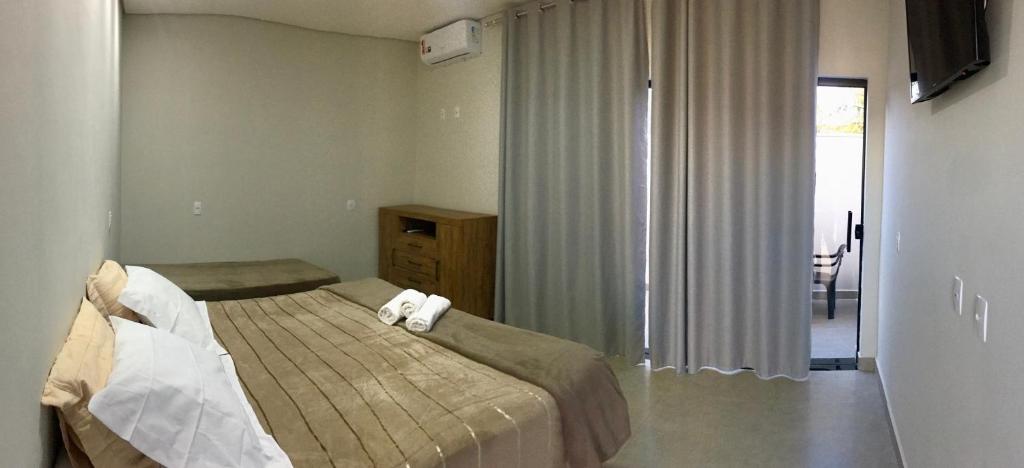 um quarto com uma cama com duas toalhas em Pousada Lobo Guará em São João Batista do Glória