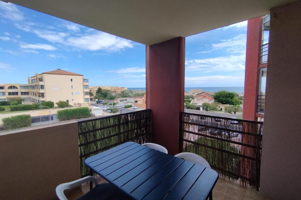un balcon avec une table et une vue sur l'océan dans l'établissement Near the port and the beach, à Frontignan