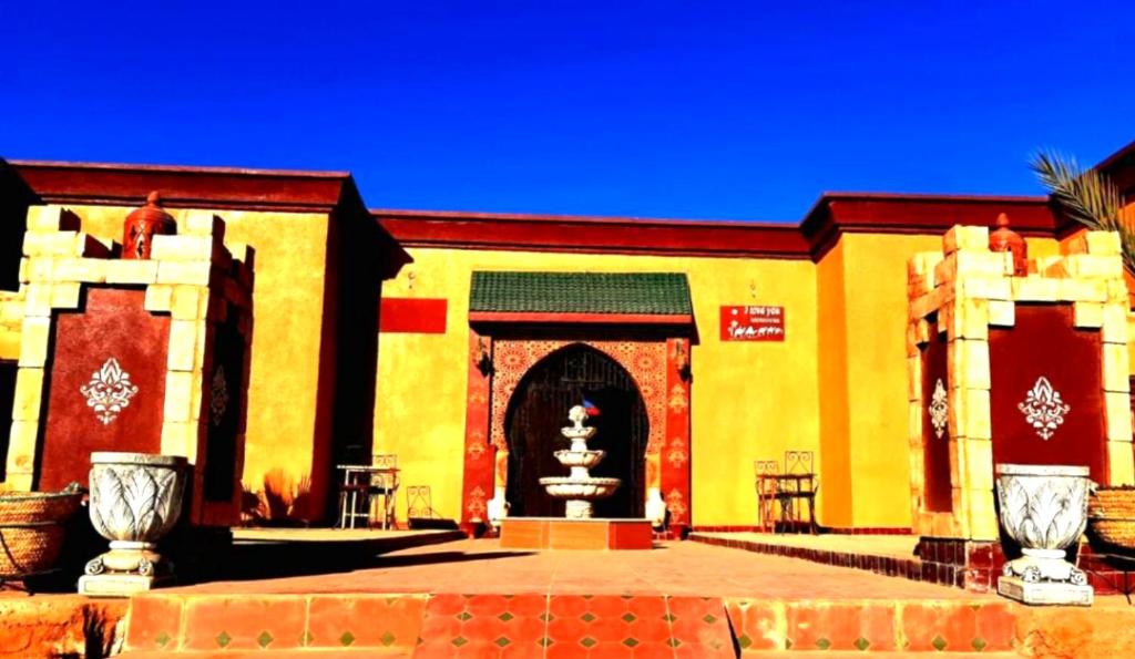a building with a fountain in front of it at Riad family in Merzouga