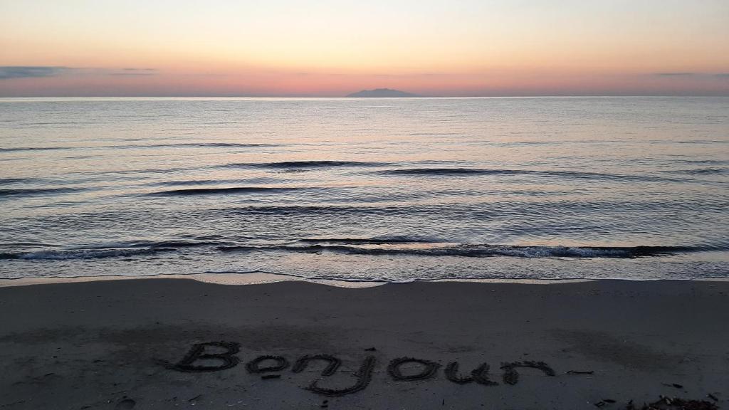 une plage avec le mot bourn écrit dans le sable dans l'établissement maison de vacance en corse, à Borgo