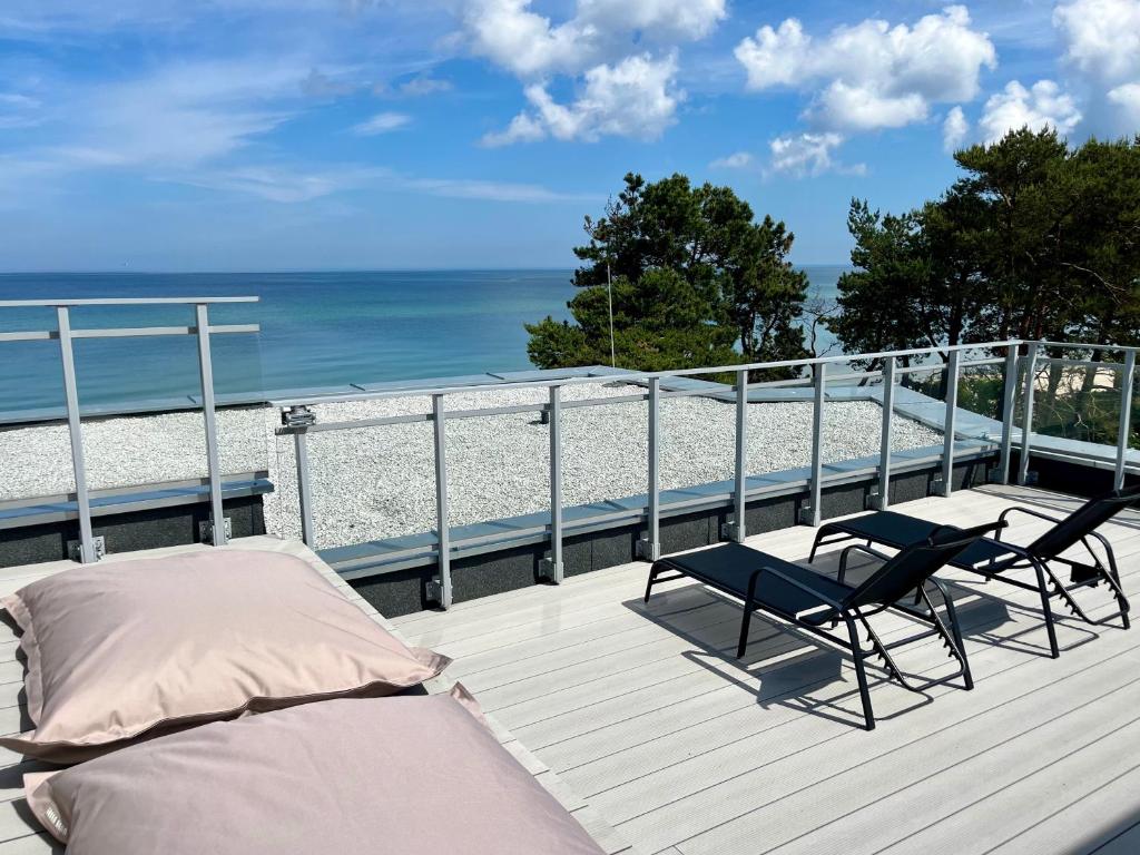 a deck with two chairs and a bed and the beach at Penthouse Apartment mit Meerblick und Dachterrasse in Gaski bei Mielno in Gąski