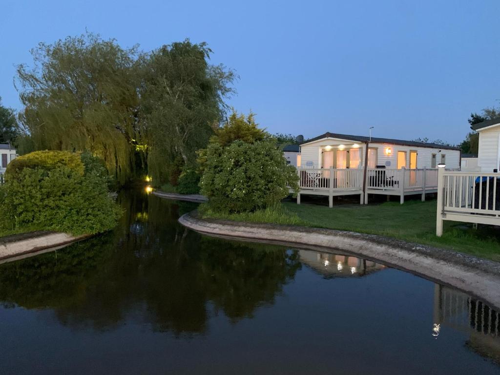 29 Morningside at Southview in Skegness - Park Dean resorts في Lincolnshire: اطلالة على نهر بالليل مع البيوت