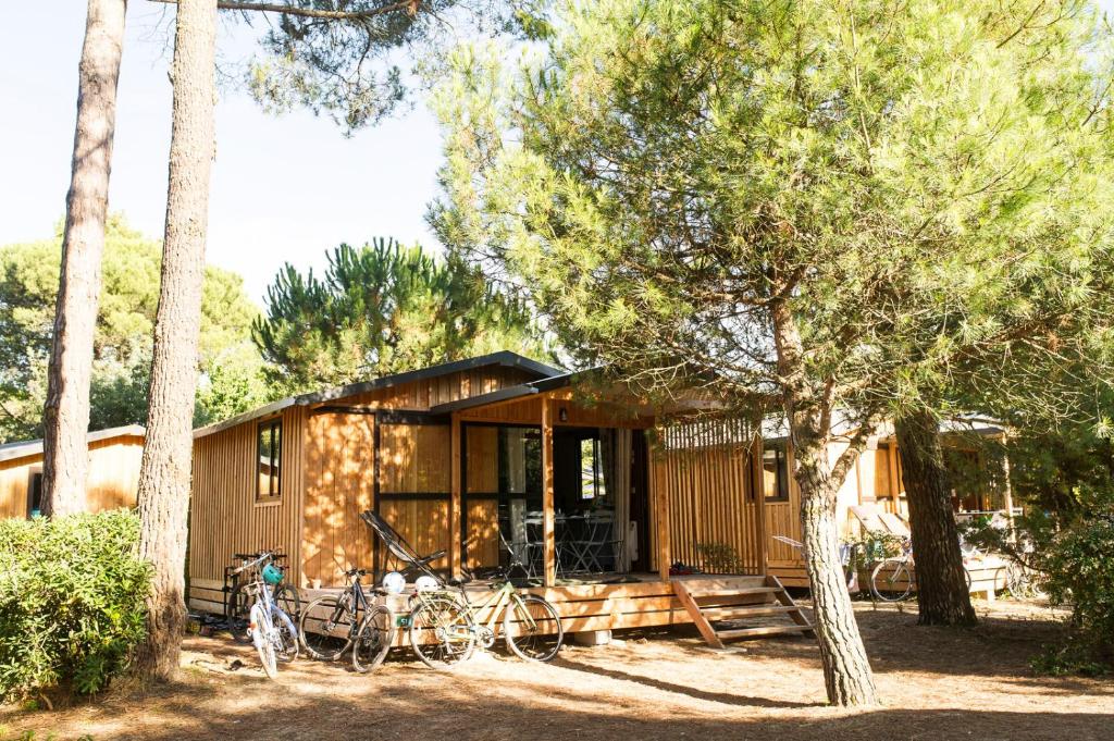 eine kleine Hütte mit Fahrrädern, die draußen geparkt sind in der Unterkunft Huttopia Chardons bleus Ile de Re in Sainte-Marie-de-Ré