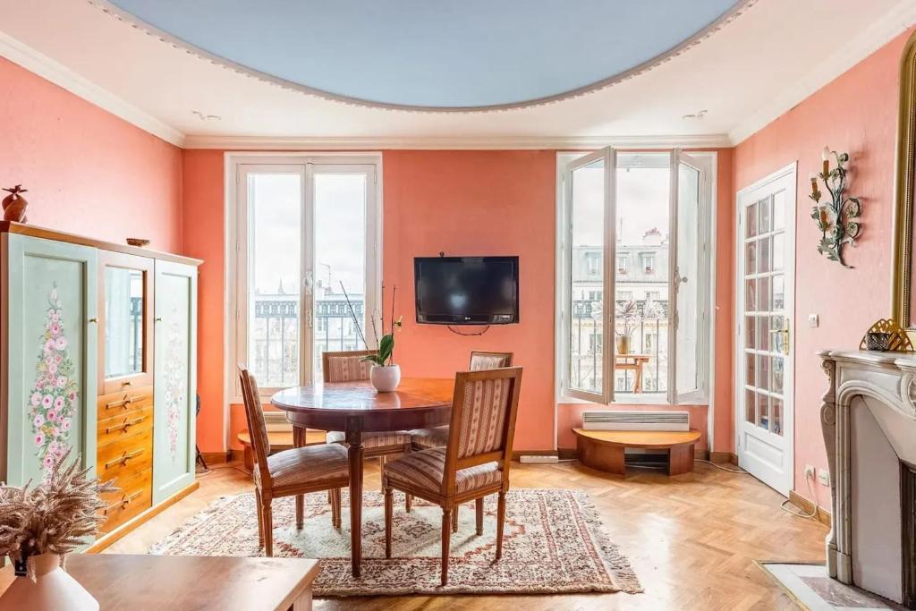 a dining room with a table and chairs and a tv at Appartement convivial à Paris avec vue panoramique ! (50 m²) in Saint-Pierre