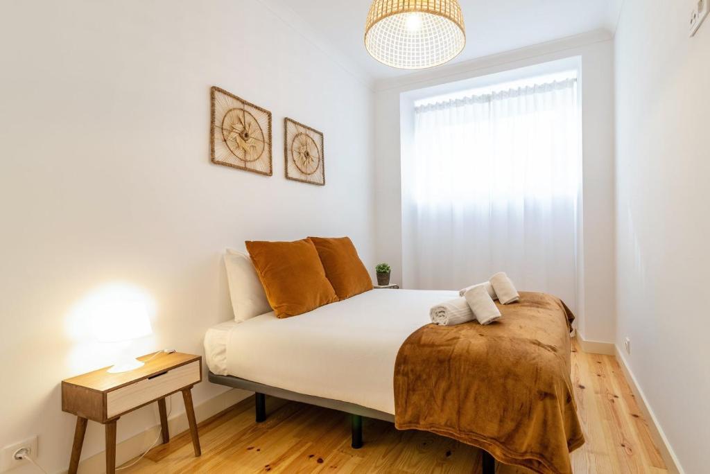 een slaapkamer met een bed en een raam bij GuestReady - Dazzling Apt with Private Terrace in Lissabon