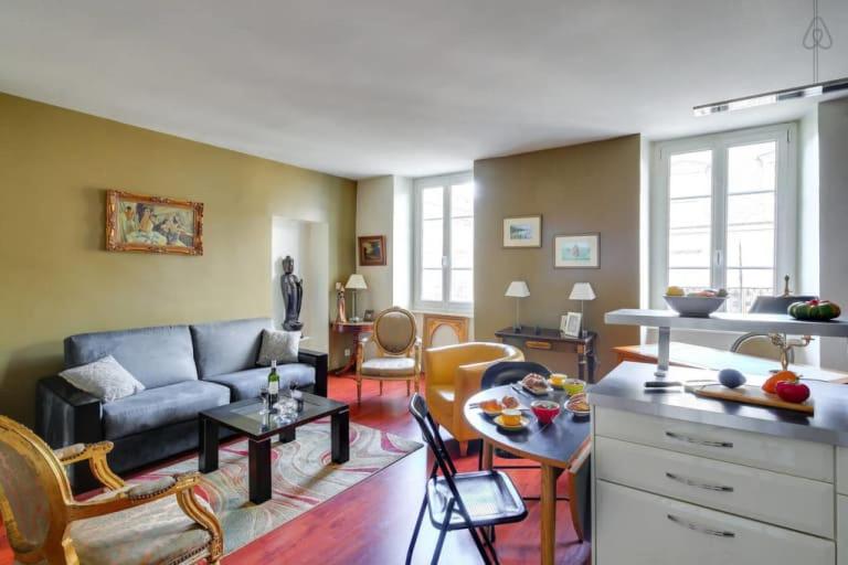 un soggiorno con divano e tavolo di GuestReady - Amazing Le Marais Flat - 2 mins to Hôtel de Ville a Parigi