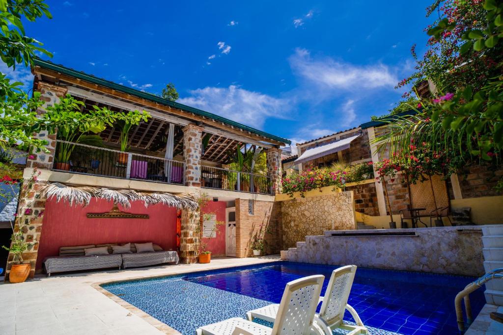 une maison avec une piscine et deux chaises dans l'établissement Casa Al Alma, à Santa Fe de Antioquia