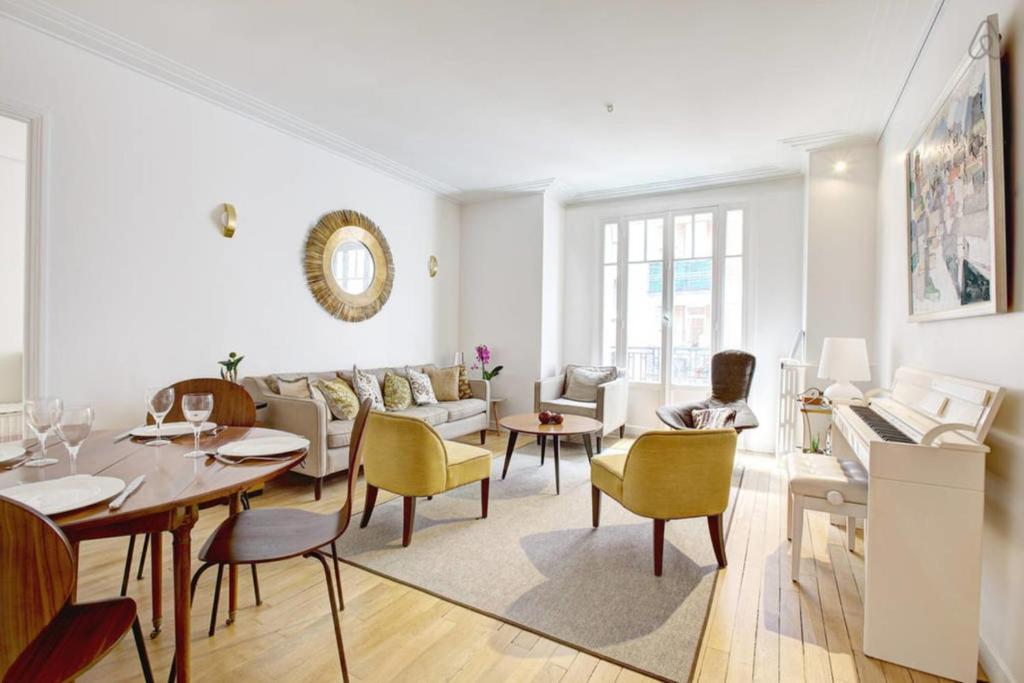 a living room with a couch and a table and chairs at GuestReady - Bright Flat at Porte d'Auteuil Metro in Paris