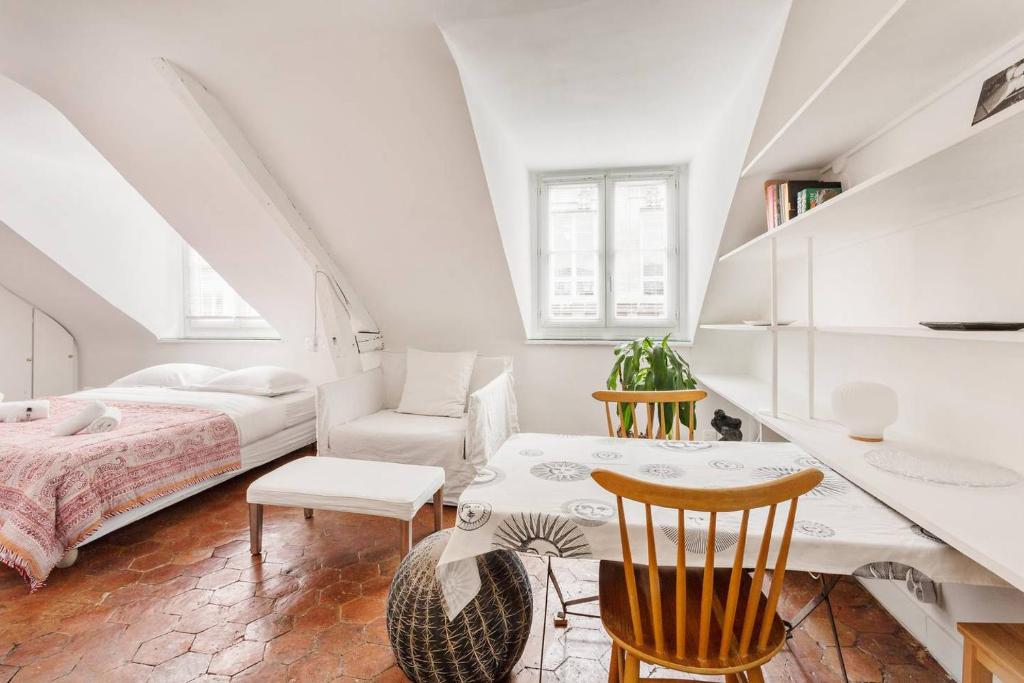 une chambre avec un lit, une table et des chaises dans l'établissement GuestReady - Confort et charme au cœur de Paris, à Paris