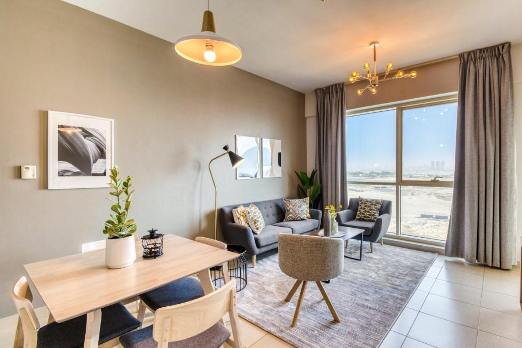 uma sala de estar com uma mesa e cadeiras e um sofá em GuestReady - Sunny Delights em Dubai