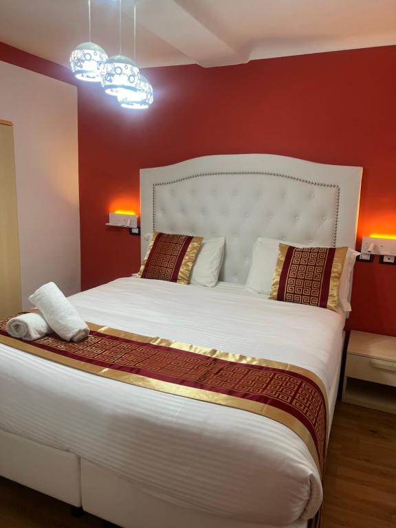 1 dormitorio con 1 cama blanca grande y paredes rojas en Hotel Veronese, en Génova