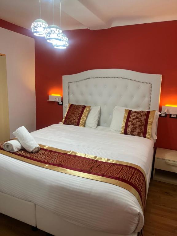 a bedroom with a large white bed with red walls at Hotel Veronese in Genova