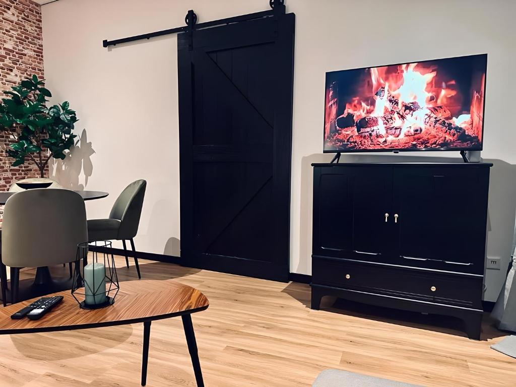 a living room with a tv on a black cabinet at FeWo Kupferkrug Historisch & Zentral in Nordhorn