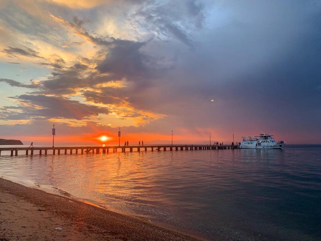 una barca è attraccata a un molo al tramonto di Aura Estiva a Agia Triada