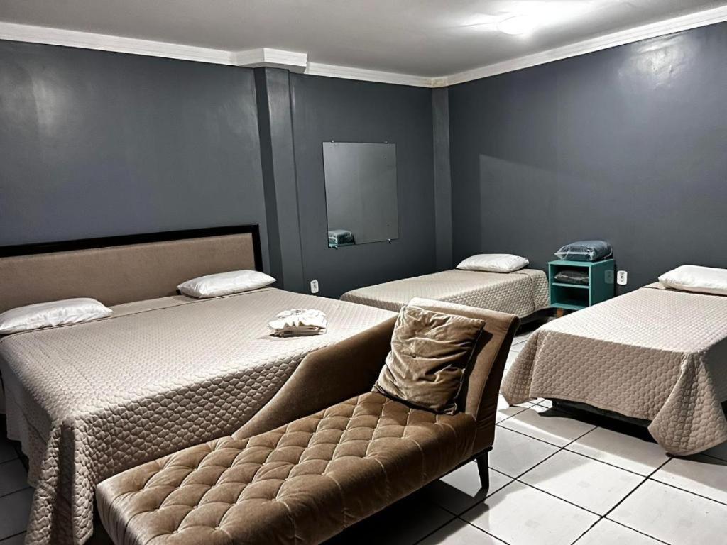 um quarto com duas camas e um sofá em Hotel Boa Viagem em Barra do Garças