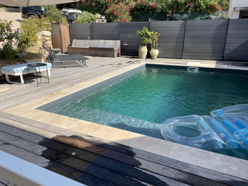 une piscine dans une cour arrière avec une table et des chaises dans l'établissement Maison avec 2 couchages piscine privative, à Ajaccio