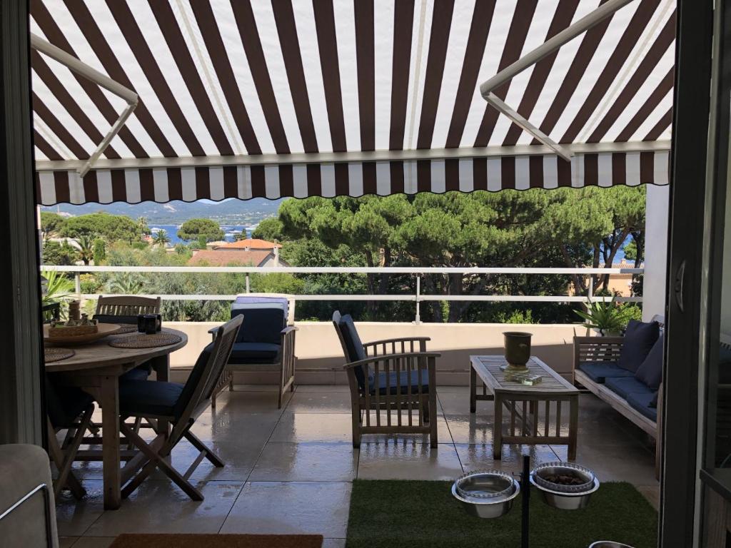 un patio avec une table et des chaises et une vue dans l'établissement appartement vue mer, à Saint-Tropez