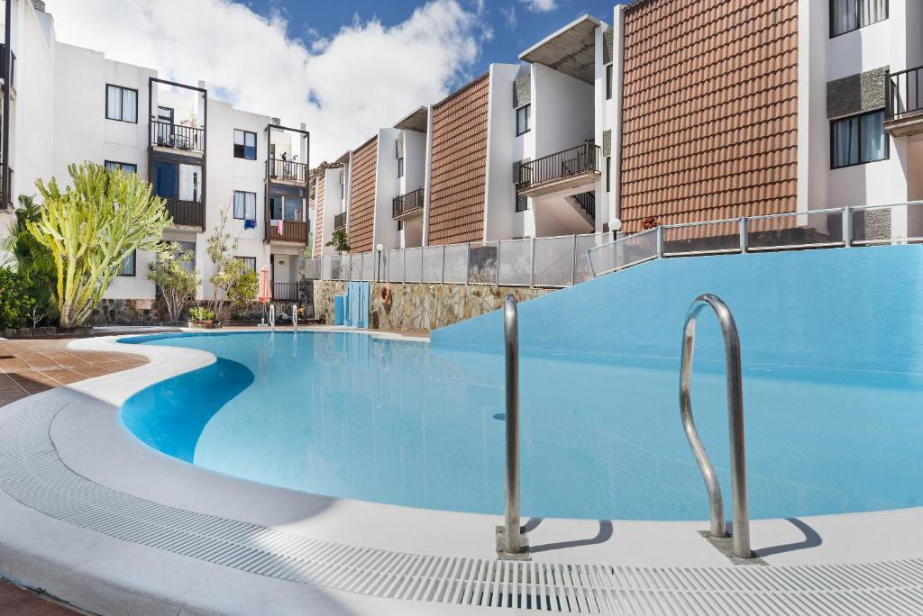 a swimming pool in an apartment with buildings at Bonita Apto Nieves in Playa de Santiago