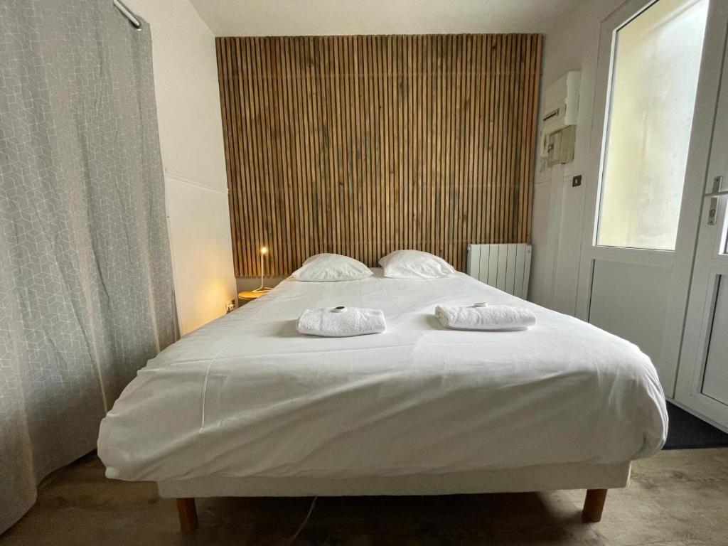 une chambre avec un grand lit blanc avec des serviettes dessus dans l'établissement Studios dans l'hyper centre Bordeaux, à Bordeaux