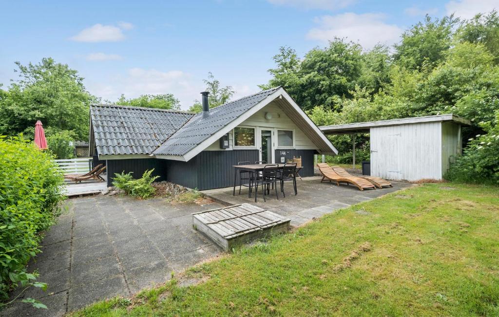ein kleines Haus mit einer Terrasse und einem Tisch in der Unterkunft 3 Bedroom Beautiful Home In Toftlund in Arrild
