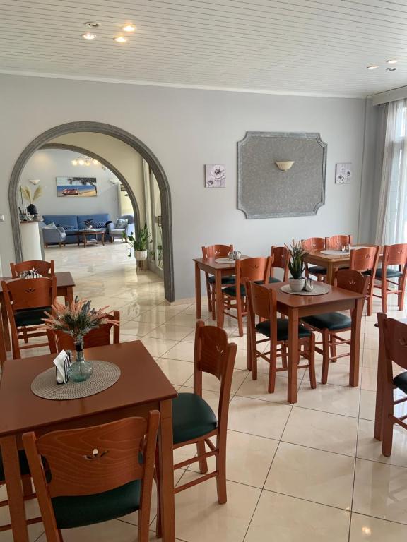 un restaurante con mesas y sillas y una sala de estar. en Isidora Hotel, en Agia Marina Aegina