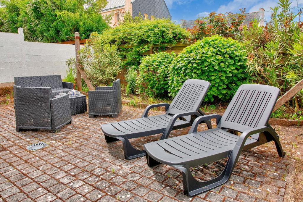 three chairs and a bench on a brick patio at Concarneau - 300m des plages in Concarneau