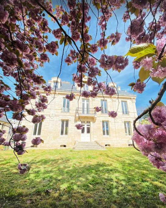 un grand bâtiment avec des fleurs roses devant dans l'établissement WeLiving, à Caen
