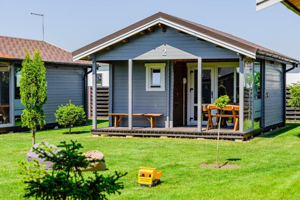 a small blue house with a table on a yard at Nameliai Penkios gulbės in Šventoji