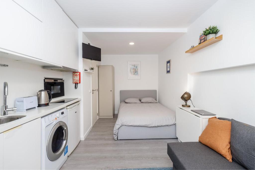 um pequeno apartamento com uma cama e uma cozinha em GuestReady - Minimalist Studio In Downtown Lisbon em Lisboa