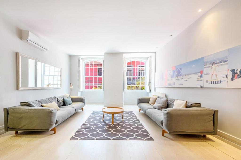 a living room with two couches and a rug at GuestReady - Newly Renovated 3BR Apartment – Chiado in Lisbon