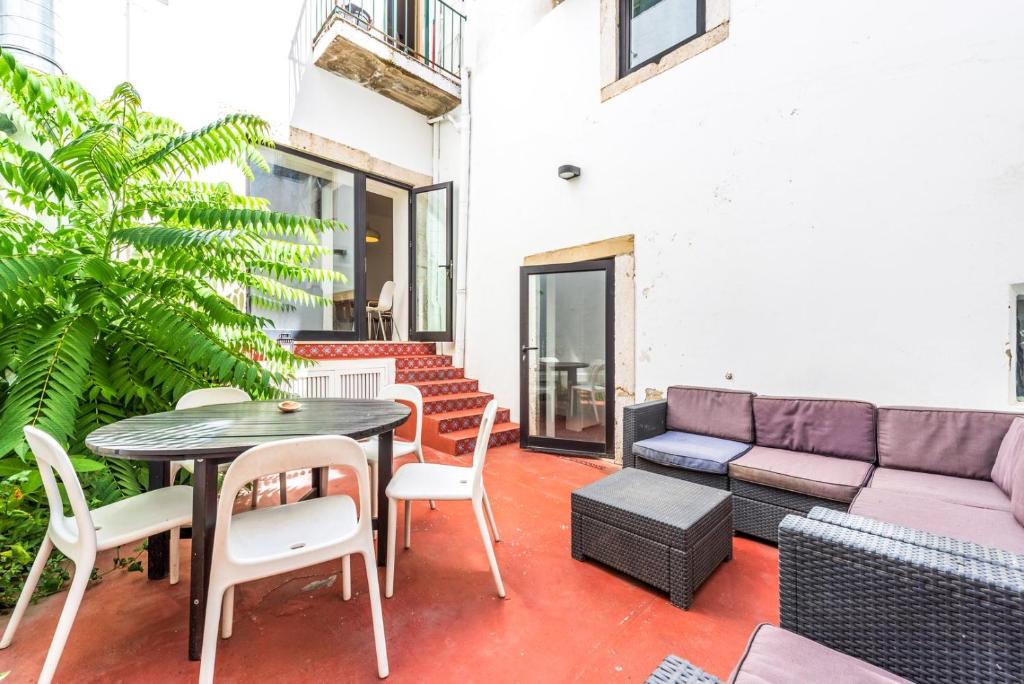 a patio with a couch and a table and chairs at GuestReady - Fantastic w Big Patio – Bairro Alto in Lisbon