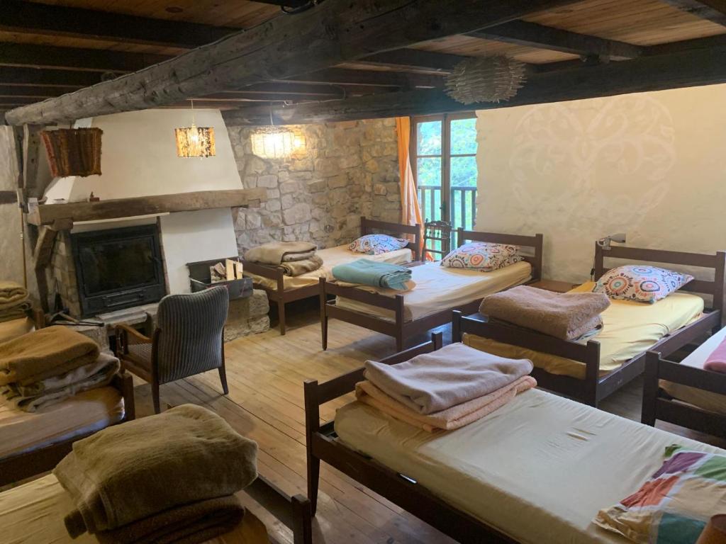 Gîte de la Bastide - Cabania Pays Cathare في Camps-sur-lʼAgly: غرفة بها العديد من الأسرة ومدفأة