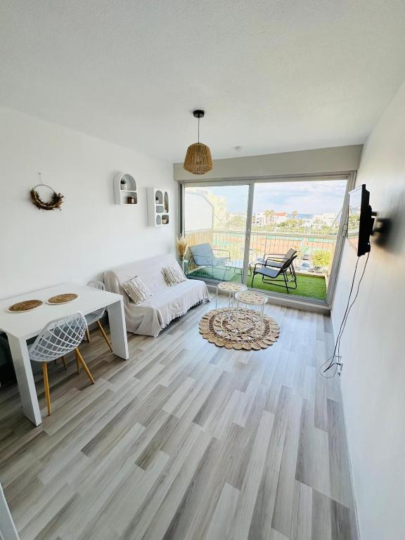 un salon avec un canapé et une table dans l'établissement Studio vue mer avec WIFI, à Mauguio