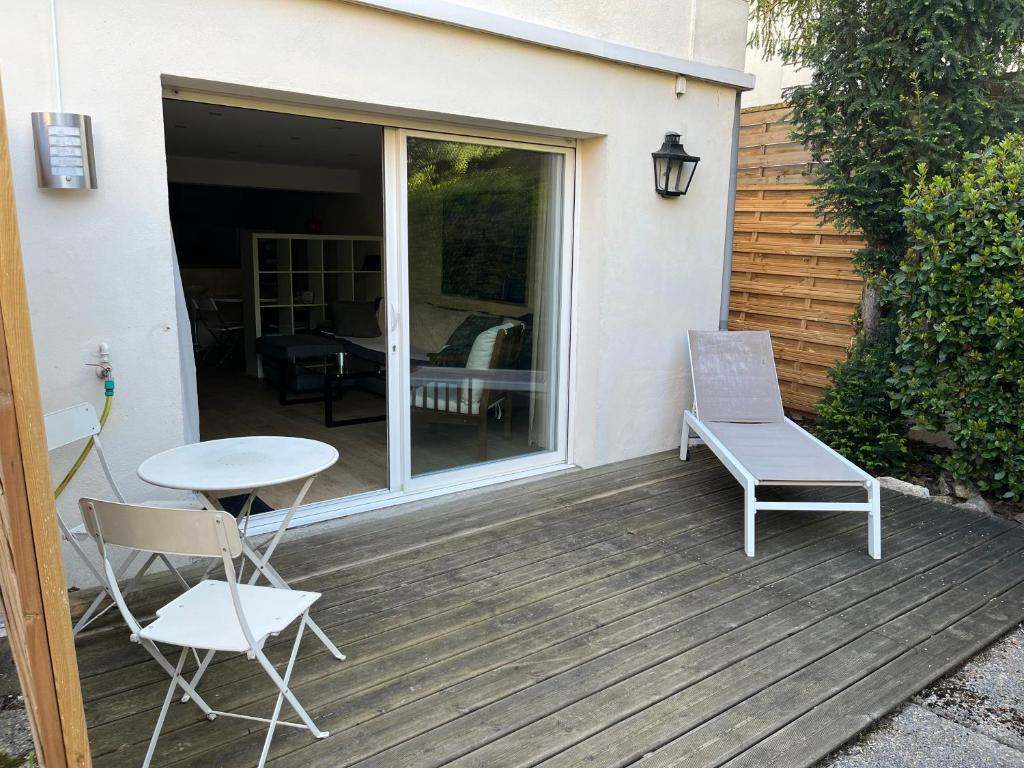 un patio avec une table et des chaises sur une terrasse dans l'établissement appartement refait neuf meublé 2 pieces, à Rueil-Malmaison