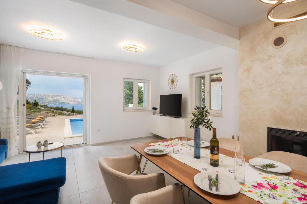 a dining room and living room with a table and chairs at Emerald Eco Villa in Novo Selo