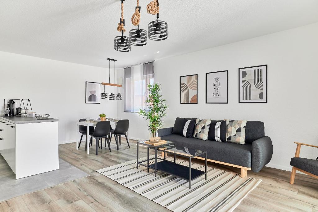 a living room with a couch and a table at Neubau Luxus Penthouse - Netflix - BBQ in Mannheim