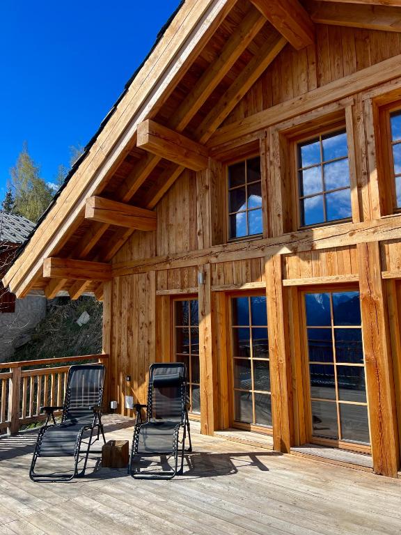 une maison avec deux chaises sur une terrasse dans l'établissement Nouveauté 2024 Chalet Le Lauzaret Villard-Reculas, à Villard-Reculas