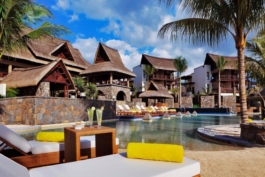 a resort with a pool with chairs and palm trees at Le Jadis Beach Resort & Wellness - Managed by Banyan Tree Hotels & Resorts in Balaclava