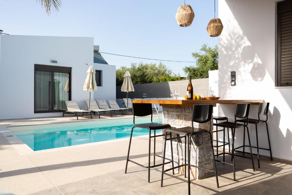 a kitchen with a bar next to a swimming pool at Villa Stavelia in Gouves