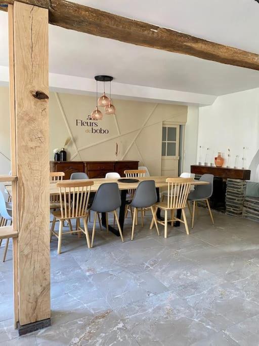 une salle à manger avec une table et des chaises dans l'établissement Maison Fleurs de bobo, à Les Minières