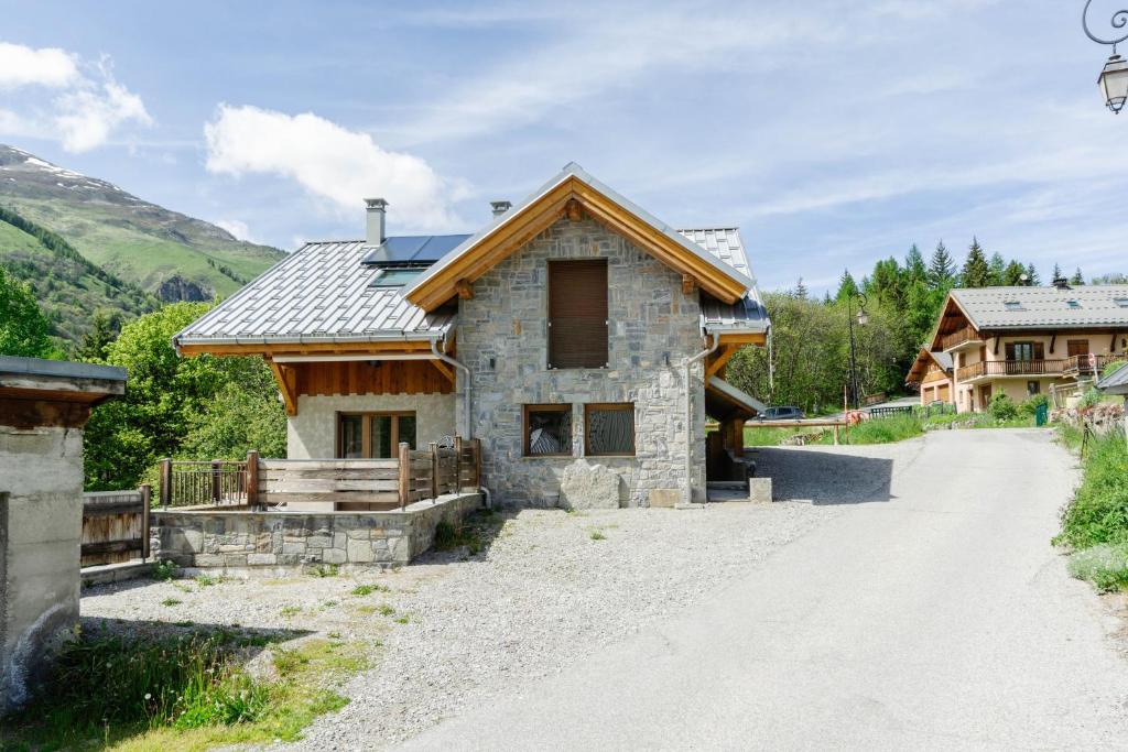 una casa en un camino de tierra junto a una montaña en Lamartine, en Valloire