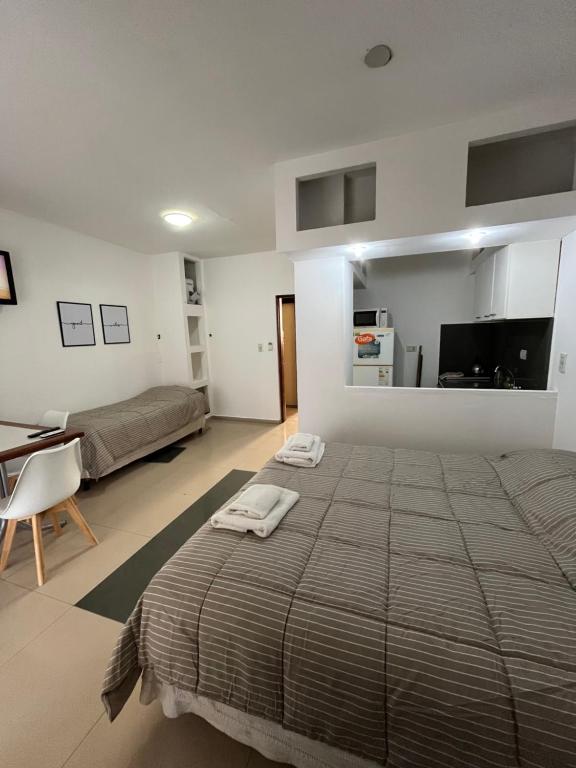 une chambre avec un grand lit avec deux serviettes dessus dans l'établissement DERC Temporarios, à Río Cuarto